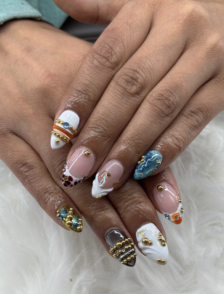 Teal and nude nail art with gold embellishments