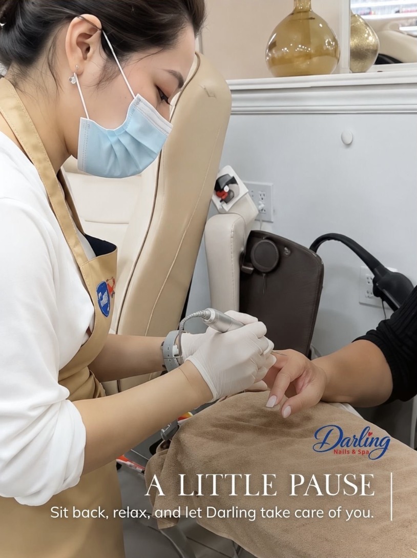 A Darling nail technician carefully working on a guest’s nails