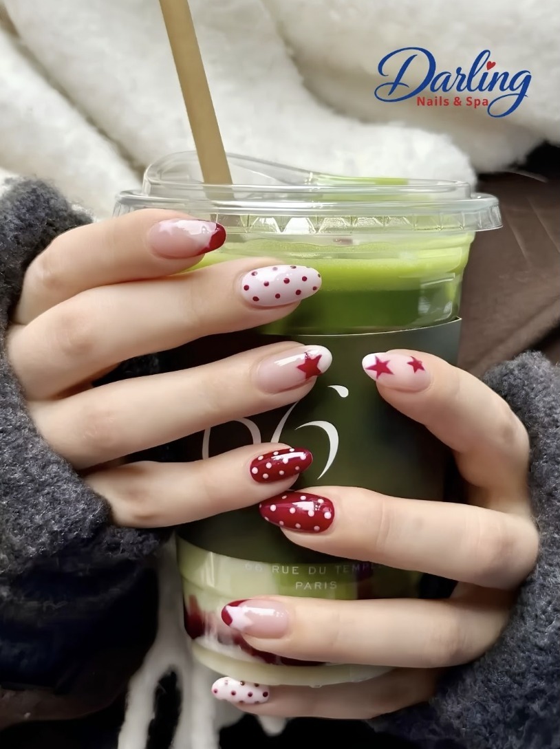Red and white nail art holding an iced matcha drink