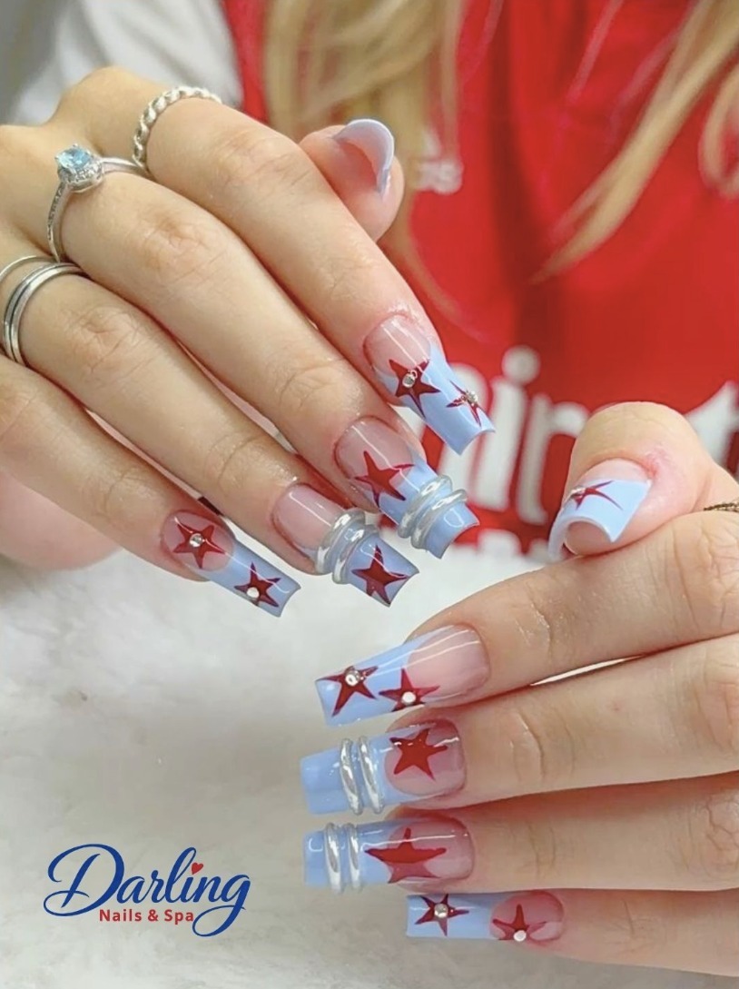 Colorful star nail art on a pale manicure